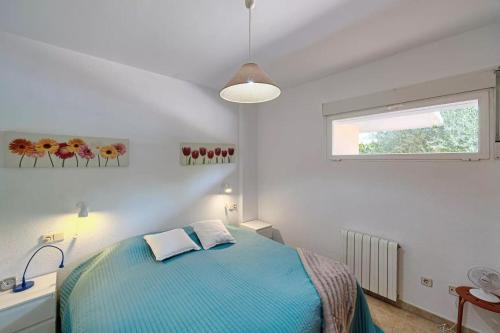 una camera da letto con un letto blu e una finestra di Alborada Golf 3BD a Albir