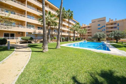 una piscina di fronte a un edificio con palme di Alborada Golf 3BD a Albir