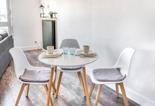une table blanche avec quatre chaises dans une pièce dans l'établissement Bourgonnier 19 - Charmant studio à Angers, à Angers