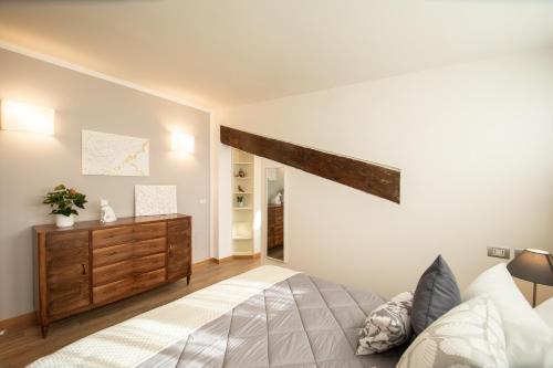 ein Schlafzimmer mit einem Bett und einer Holzkommode in der Unterkunft Rooftop Delight with Terrace in Lucca