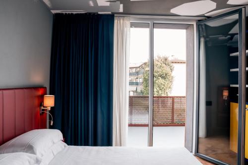 um quarto com uma cama e uma porta de vidro deslizante em K MODERN HOTEL em Peschiera del Garda
