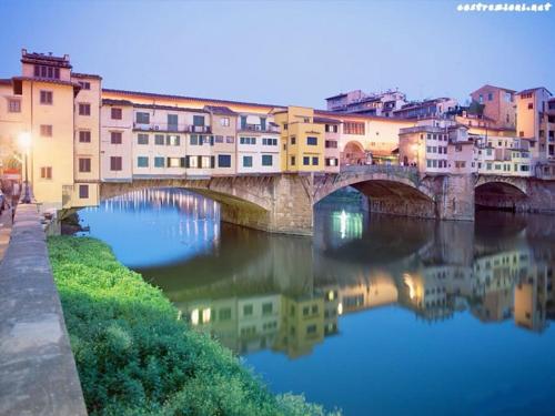 un puente sobre un río en una ciudad en Lorenzo Magnifico Typical Home Heart of Florence, en Florencia