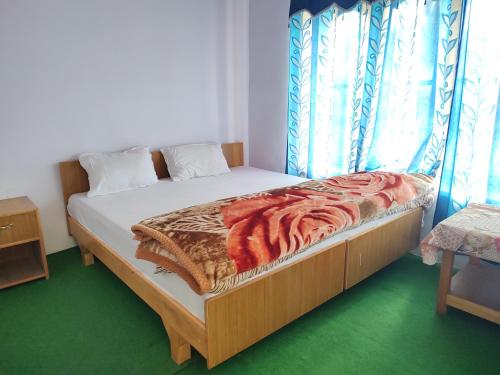 a bedroom with a bed with a blanket on it at Skayil House in Nubra