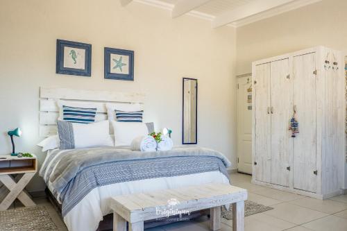 a bedroom with a bed with blue and white pillows at Forever Blue in St Helena Bay