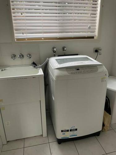 a washer and dryer in a room with a window at Our Townhouse in Toowoomba in Toowoomba