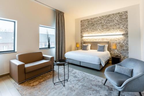 une chambre d'hôtel avec un lit et une chaise dans l'établissement Hotel Stayen, à Saint-Trond