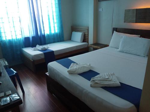 a hotel room with two beds with towels on them at Casa Montemar Bed and Breakfast in Coron