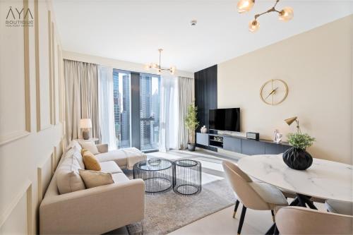 a living room with a couch and a table at Fancy One Bedroom Apartment in Downtown Dubai By ĀYA Boutique in Dubai