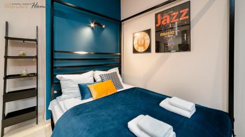 a bedroom with a blue and white bed with pillows at Wonder Home - Apartamenty w przyziemiu - cicha okolica in Karpacz