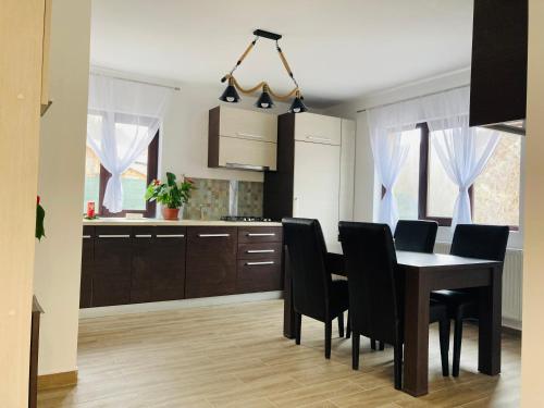 a kitchen and dining room with a table and chairs at Casa cu Scări in Lunca Mare