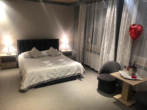 a bedroom with a bed and a chair and two lamps at Sosnowe Zacisze in Białystok