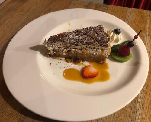 a piece of cake on a white plate with fruit at Sosnowe Zacisze in Białystok