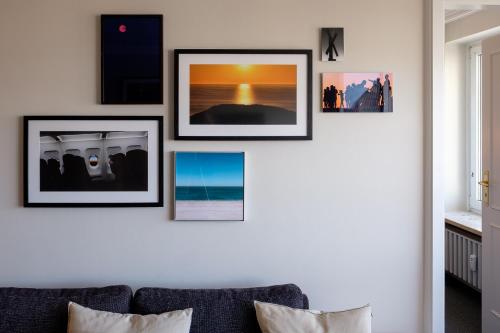 een woonkamer met vier foto's aan de muur bij Sola Bona 24 in Westerland