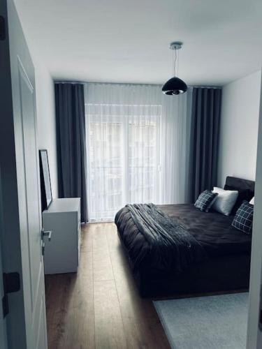 a bedroom with a bed and a large window at Priam Apartment in Pristina