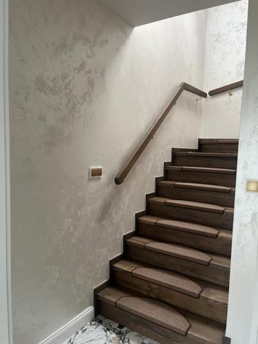 a staircase with brown carpeting and a stair case at Apartament Złoty 2 in Cieciorka