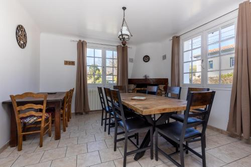 une salle à manger avec une table et des chaises en bois dans l'établissement Maison Pikassariko - 4 Chambres proche frontière espagnole, à Sare
