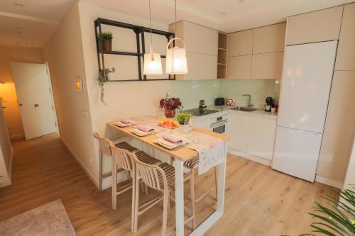 a kitchen with a table and chairs in a room at APARTAMENTOS LOS QUESEROS in Quintanadueñas