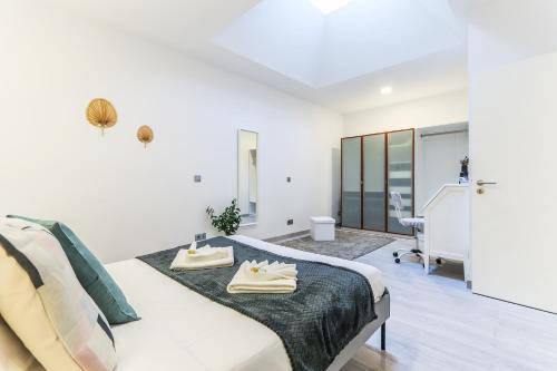 a white bedroom with a bed and a desk at Vita Portucale ! Moscavide Family Apartment in Lisbon
