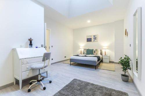 a bedroom with a bed and a desk and a chair at Vita Portucale ! Moscavide Family Apartment in Lisbon