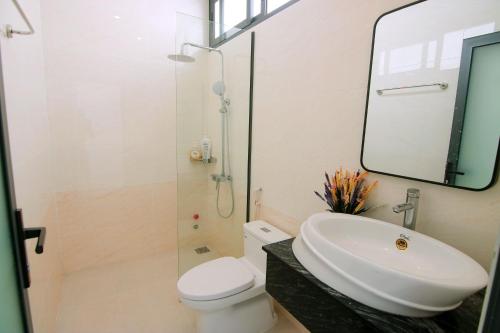 ein Badezimmer mit einem Waschbecken, einem WC und einem Spiegel in der Unterkunft Sea Villa Bãi Dâu View Biển - Đi Bộ Ra Biển in Vũng Tàu