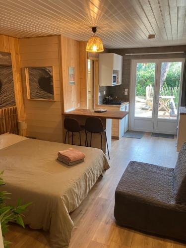a bedroom with two beds and a kitchen with a table at Appartements 2 Pièces Plage Sud à 200M in Lacanau-Océan