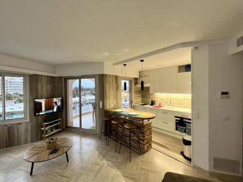 eine Küche mit einer Theke und einem Tisch in einem Zimmer in der Unterkunft Studio moderne - Port de Mandelieu - Proche Mer in Mandelieu-la-Napoule