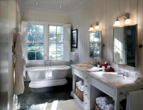 a bathroom with two sinks and a tub and a large mirror at Montage Palmetto Bluff in Bluffton