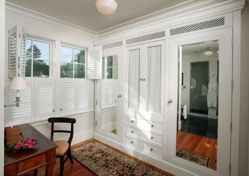 a home office with white walls and a desk and windows at Montage Palmetto Bluff in Bluffton