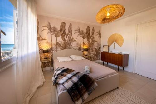 um quarto com uma cama, uma secretária e uma janela em 06B - Beau 2 pièces rénové avec terrasse vue mer em Roquebrune-Cap-Martin