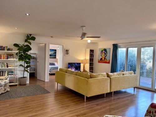 a living room with a couch and a bedroom at Magic Beach Cottage in Venus Bay