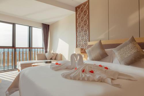 a bedroom with a large white bed with flowers on it at White Swan Guest House MeiZhou in Meizhou