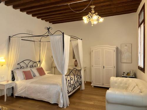 a bedroom with a canopy bed and a couch at Residenza Corte Antica in Venice