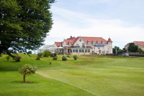 a large house on a golf course with a green at North Shore Hotel in Skegness