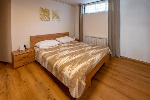 sypialnia z dużym łóżkiem i oknem w obiekcie Alpski škrat, Kranjska Gora w mieście Kranjska Gora