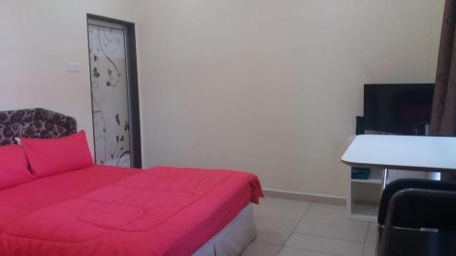 a bedroom with a red bed and a desk at GLG KLIA Transit House in Sepang
