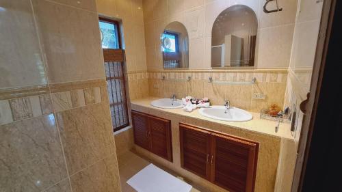uma casa de banho com 2 lavatórios e um chuveiro em Beautiful bungalow with a communal outdoor pool and 2 km from the sandy beach em Ban Sa