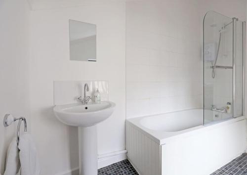 a white bathroom with a sink and a shower at Cowgate Rest in Norwich