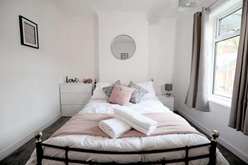 a bedroom with a bed with pink and white pillows at Cowgate Rest in Norwich