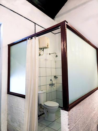 a bathroom with a toilet and a shower at goSTOPS Lite Alleppey in Alleppey