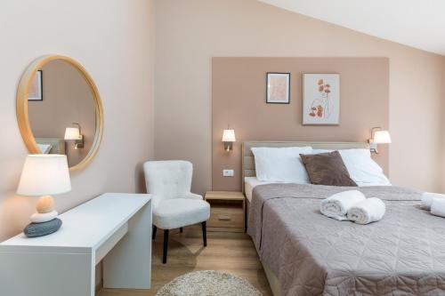 a bedroom with a bed and a mirror and a chair at wine house apartments& rooms Marčeta in Fažana