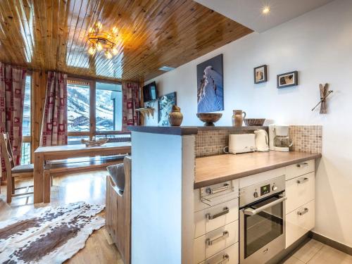 - une cuisine avec un comptoir et une cuisinière dans l'établissement Appartement de charme centre ville, 6-7 pers, proche pistes et commerces, WiFi - FR-1-519-13, à Val dʼIsère