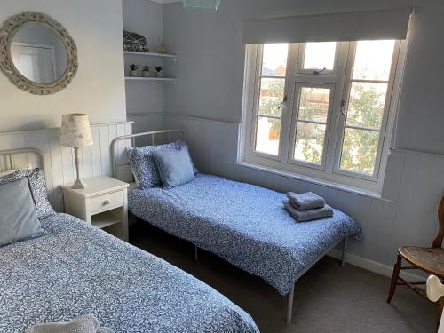 a small bedroom with two beds and a mirror at Demeter Cottage in Whitby