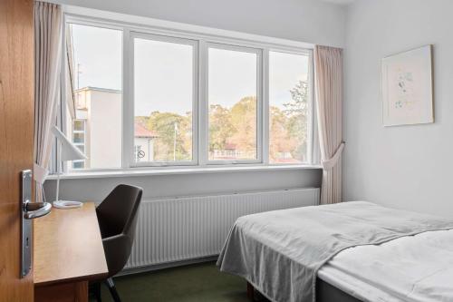 a hotel room with a bed and a window at Gl Skovridergaard in Silkeborg