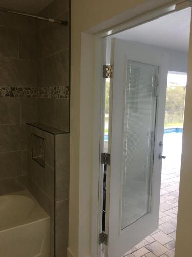 La salle de bains est pourvue d'une douche et d'une porte en verre. dans l'établissement Stunning New Home in Cape Coral Florida, à Cape Coral