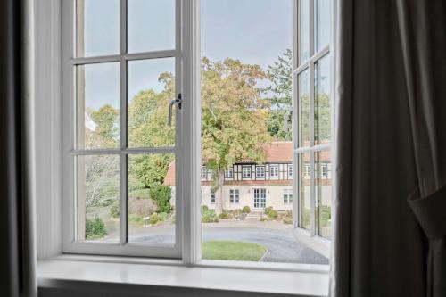 an open window with a view of a building at Gl Skovridergaard in Silkeborg