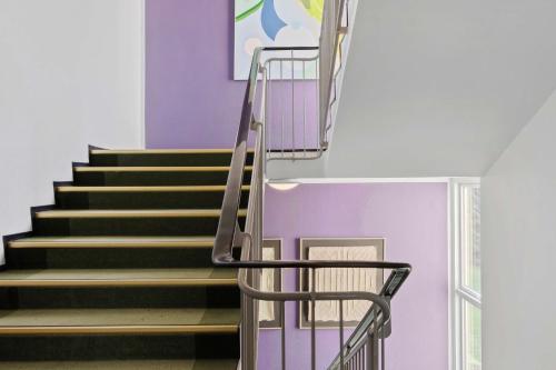 a metal staircase in a room with purple walls at Gl Skovridergaard in Silkeborg