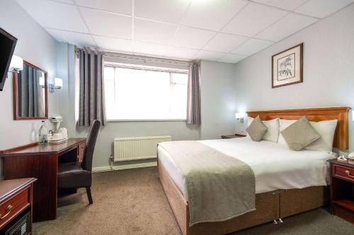 a hotel room with a bed and a desk and a window at Comfort Inn Birmingham in Birmingham
