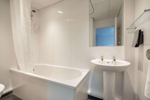 a white bathroom with a sink and a bath tub at Comfort Inn Birmingham in Birmingham