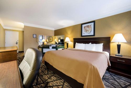 a hotel room with a large bed and a desk at Quality Inn and Suites Fairgrounds - Syracuse in Liverpool