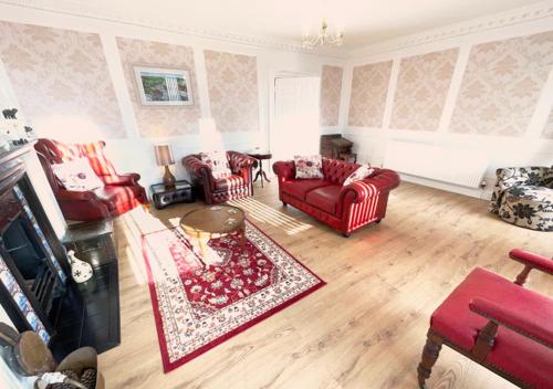a living room with red furniture and a red rug at The Georgian Apartment in Gosport